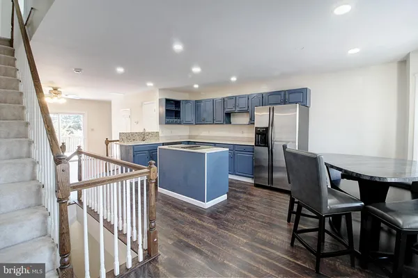 a kitchen with kitchen island wooden cabinets and stainless steel appliances