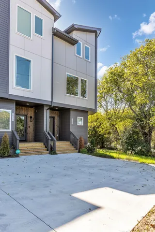 a view of a brick house with a yard and plants