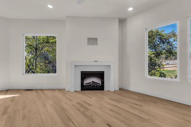 a view of an empty room with a window and fireplace