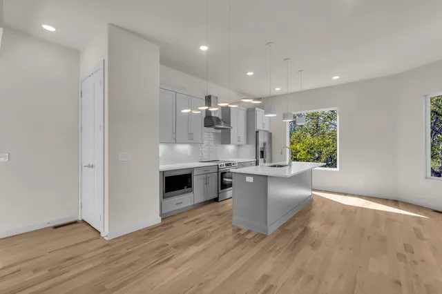 a large kitchen with a wooden floor and a sink