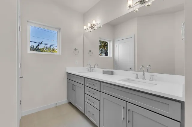 a bathroom with a double vanity sink and a mirror