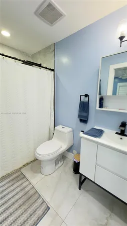 a bathroom with a toilet a sink and a mirror