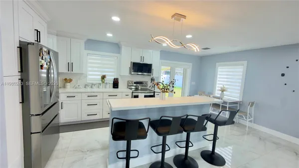 a kitchen with stainless steel appliances a refrigerator and a stove top oven