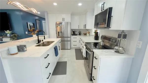 a kitchen with a sink a stove top oven a refrigerator a counter top space and cabinets