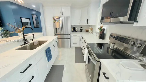 a kitchen with stainless steel appliances a sink stove and refrigerator