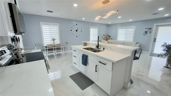 a kitchen with stainless steel appliances granite countertop a sink a stove and a refrigerator
