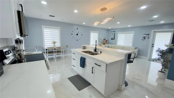 a kitchen that has a sink a stove and a refrigerator