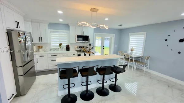 a kitchen with stainless steel appliances a sink cabinets and refrigerator