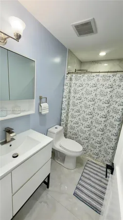 a bathroom with a sink a toilet and shower curtain