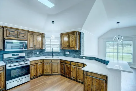 a kitchen with a sink stove and wooden cabinets