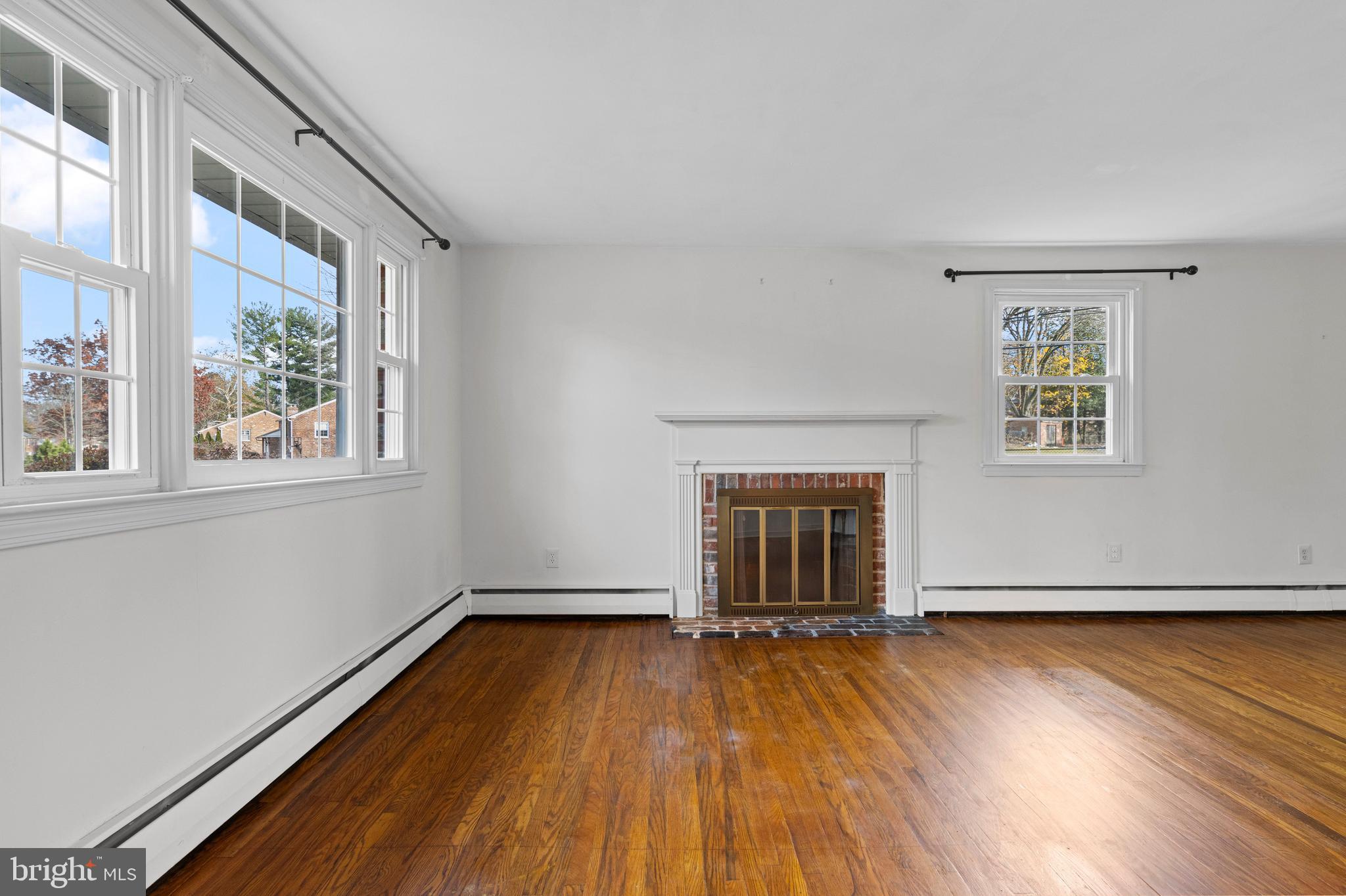 320 Landsende Road Devon, PA 19333 - Photo 6 of 26 an empty room with wooden floor fireplace and windows