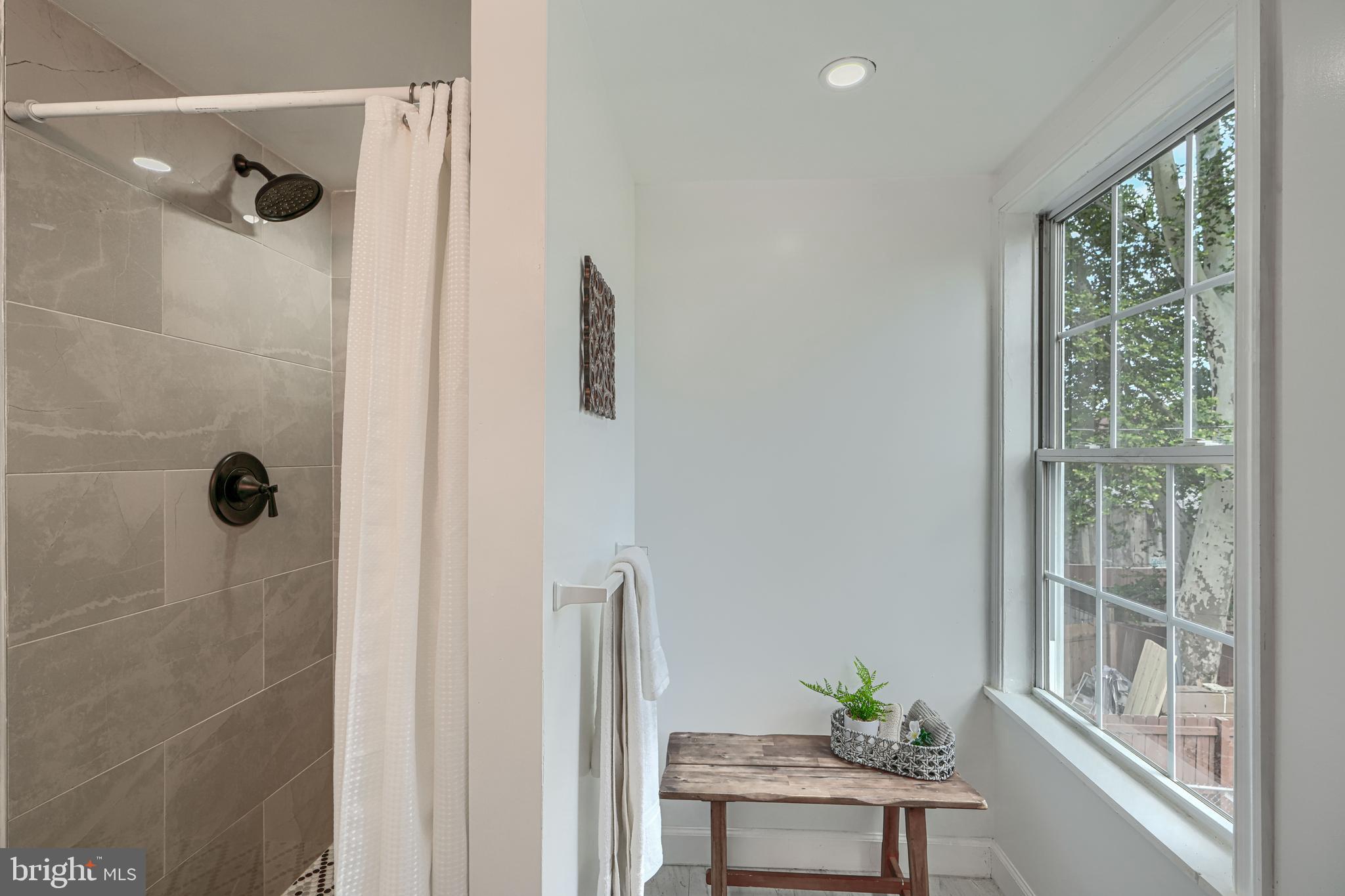 427 East 27th Street Baltimore, MD 21218 - Photo 17 of 24 a bathroom with a shower and a window