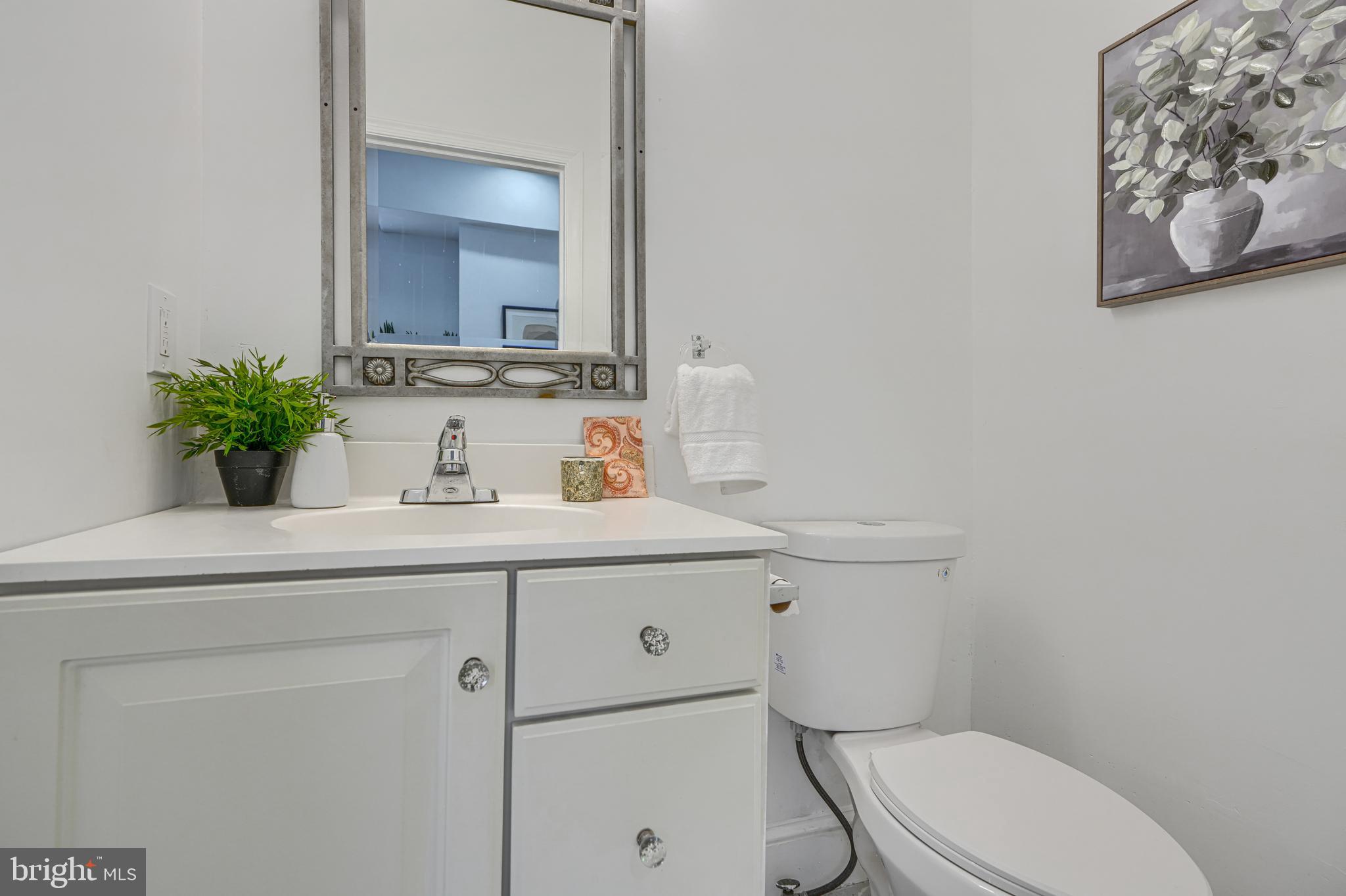 427 East 27th Street Baltimore, MD 21218 - Photo 9 of 24 a bathroom with a toilet a sink and mirror