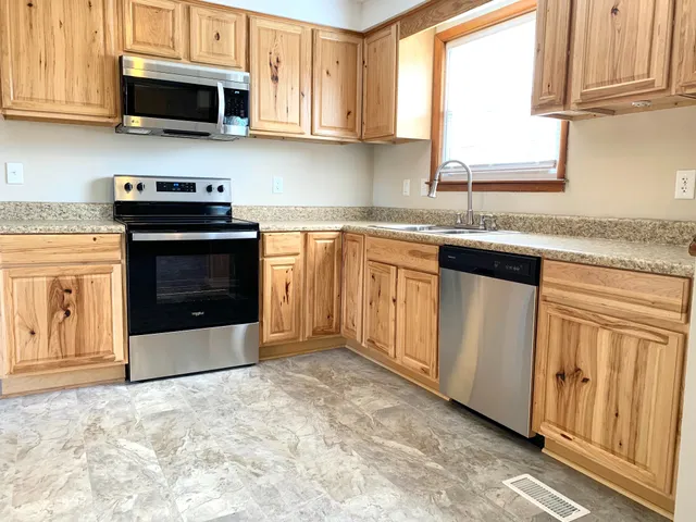 a kitchen with granite countertop a stove top oven microwave and cabinets