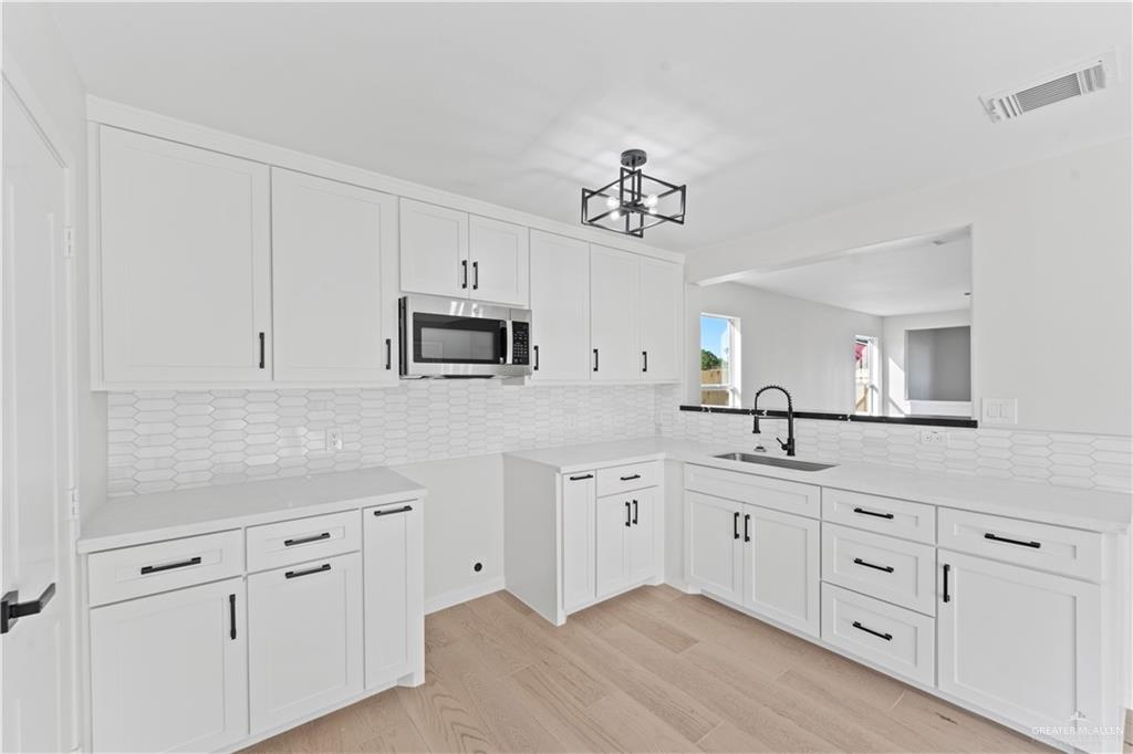 6300 North 21st Street McAllen, TX 78504 - Photo 2 of 19 a kitchen with white cabinets and sink