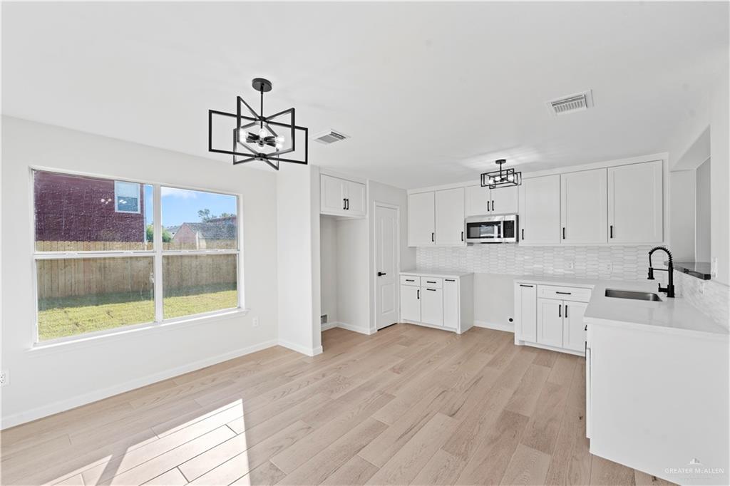 6300 North 21st Street McAllen, TX 78504 - Photo 4 of 19 a kitchen with stainless steel appliances granite countertop a sink cabinets and wooden floor