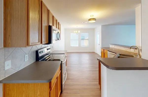 a kitchen with stainless steel appliances granite countertop a sink a stove and a refrigerator
