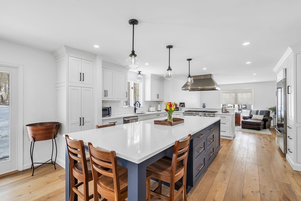 84 Jefferson Road Franklin, MA 02038 - Photo 15 of 39 a kitchen with stainless steel appliances kitchen island granite countertop a table chairs stove and white cabinets