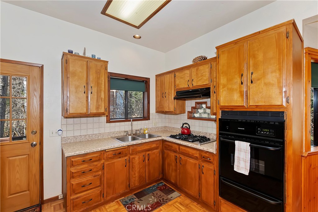 26285 Augusta Drive Lake Arrowhead, CA 92352 - Photo 31 of 47 a kitchen with stainless steel appliances granite countertop a stove sink and cabinets