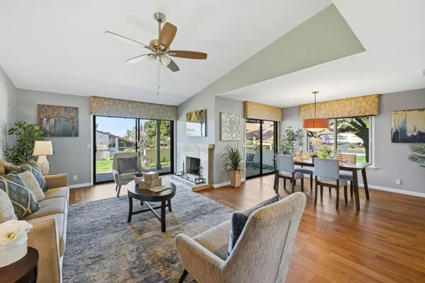 a living room with furniture a flat screen tv and a large window