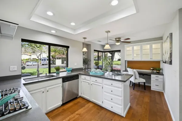 a kitchen with a sink a stove and wooden floor