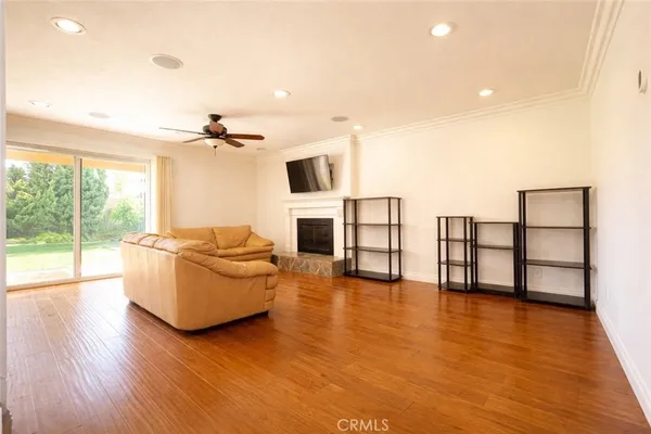 a living room with furniture floor to ceiling window and wooden floor