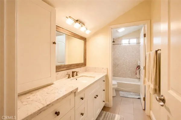 a bathroom with a tub a sink and a mirror