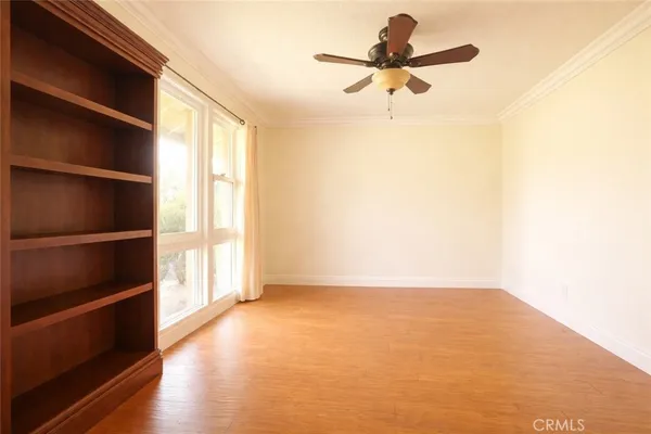 a view of an empty room with a window and a ceiling fan