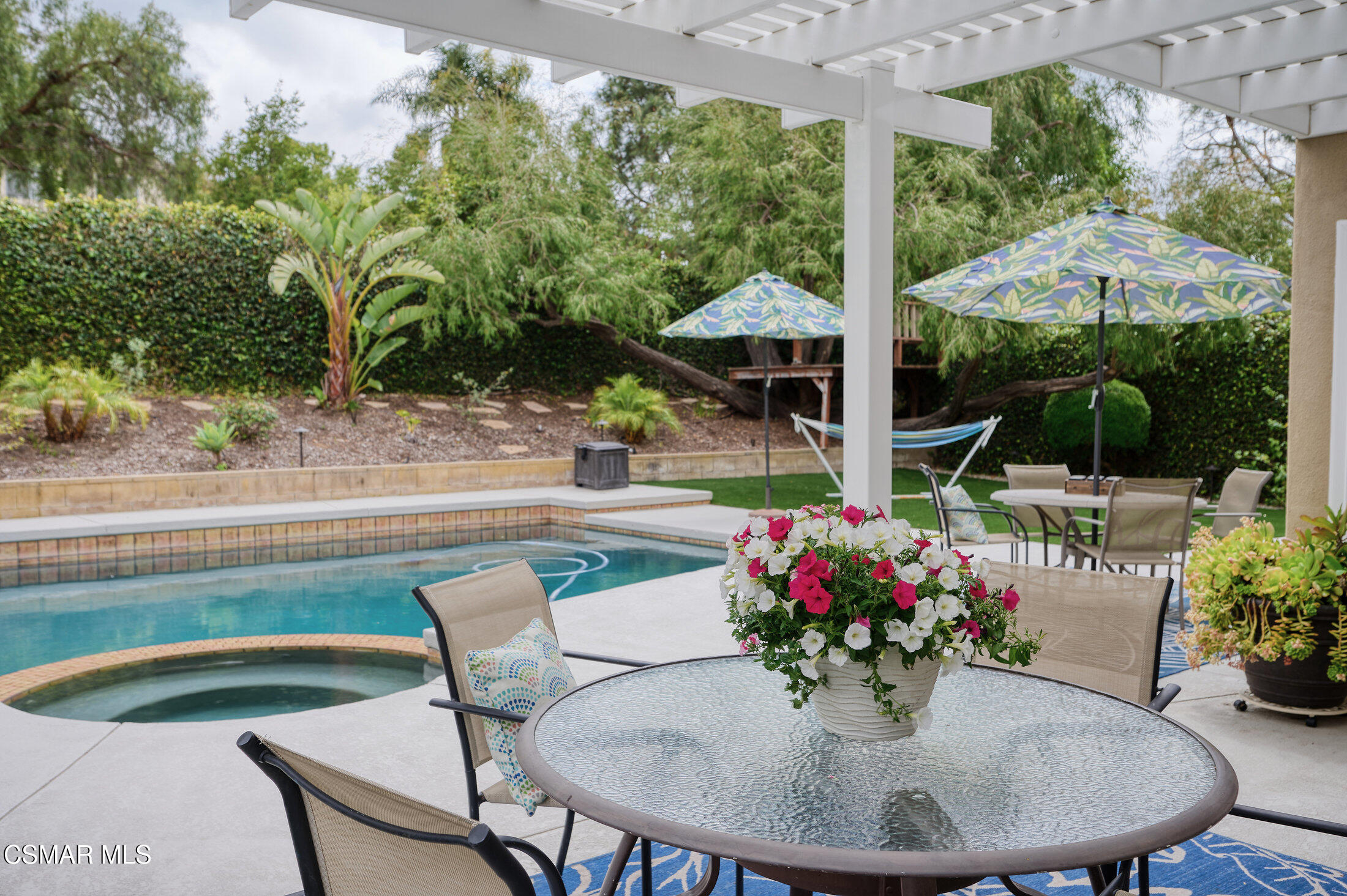 12142 Cherry Grove Street Moorpark, CA 93021 - Photo 31 of 36 a view of a dining table and chairs in patio with a swimming pool