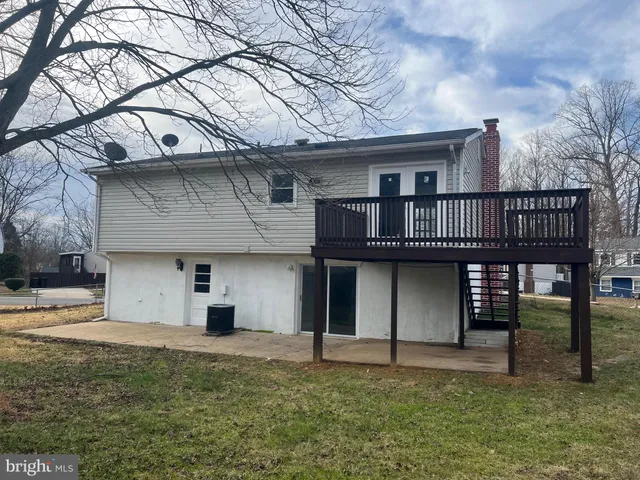 a view of a house with a yard and large tree