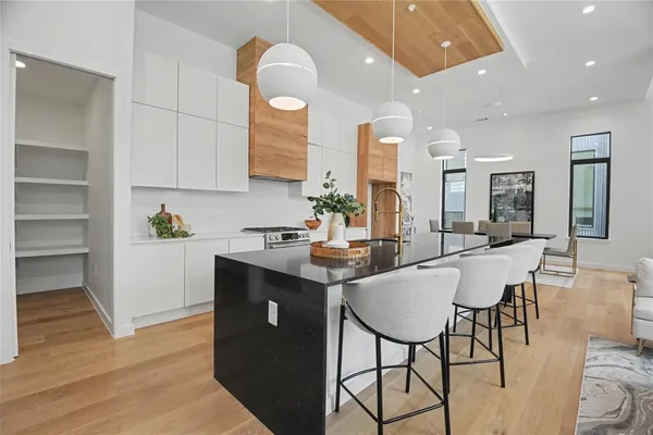 a kitchen with a dining table chairs sink and cabinets