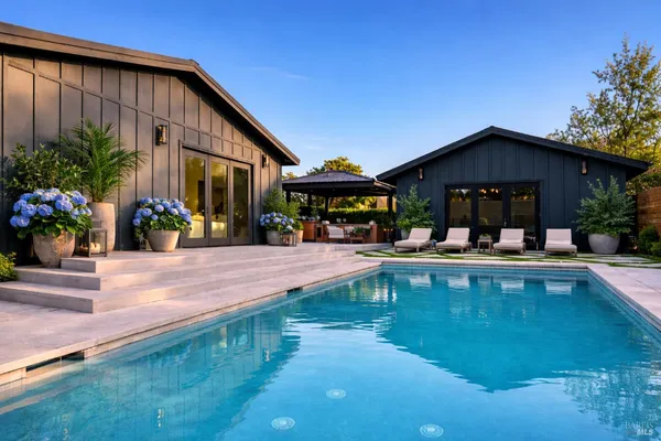 a view of a house with swimming pool and sitting area