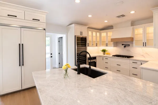 a kitchen with stainless steel appliances kitchen island granite countertop a refrigerator and a stove top oven