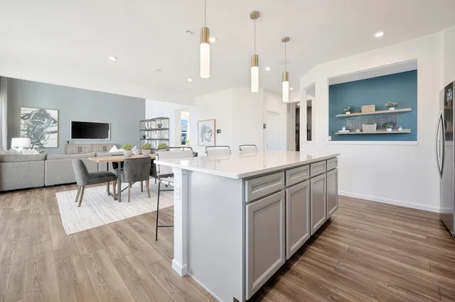 a large white kitchen with wooden floor