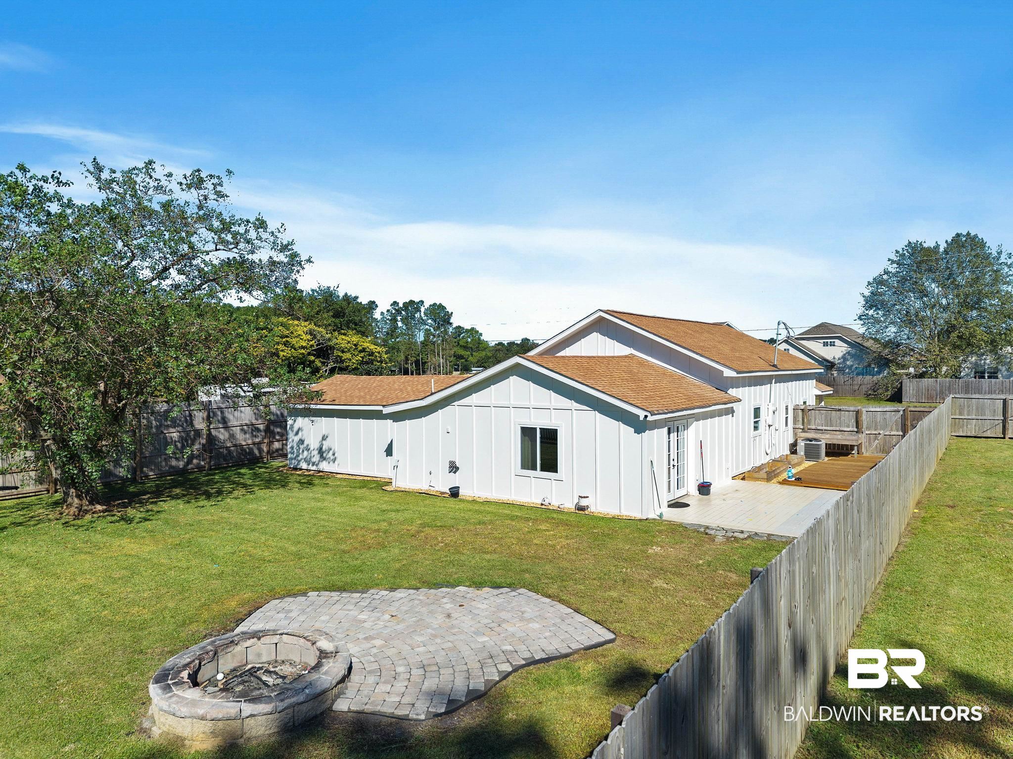 16796 Thompson Road Loxley, AL 36551 - Photo 54 of 93 Rear view of house featuring an outdoor fire pit, a fenced backyard, and board and batten siding