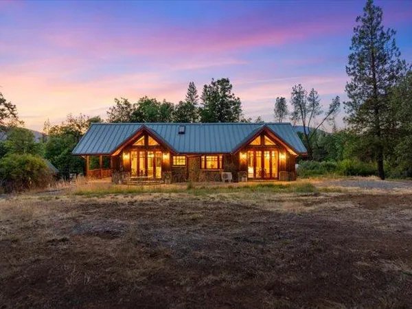 a view of backyard with wooden fence and large trees