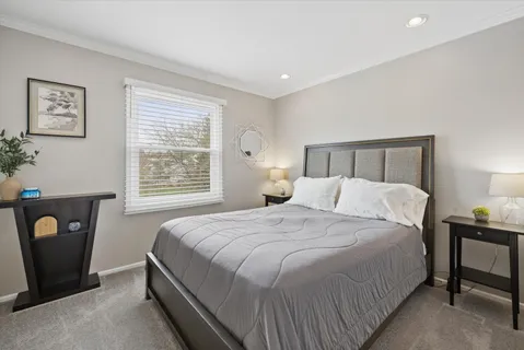 a large bed sitting in a bedroom next to a window