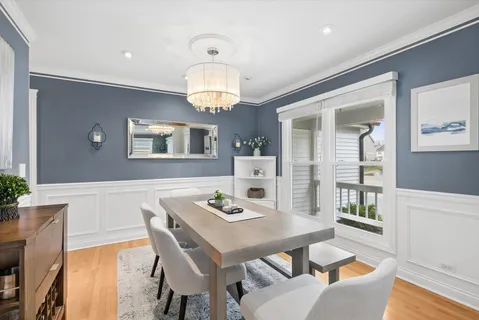 a view of a dining room with furniture a chandelier and wooden floor