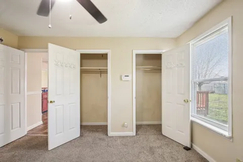 an empty room with closet and a chandelier fan