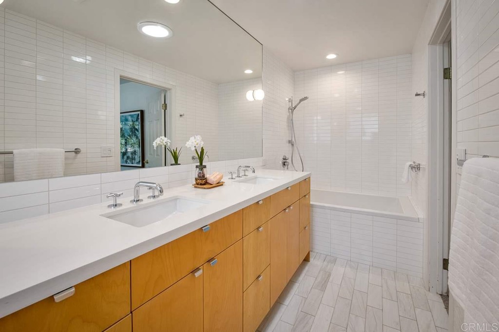 405 9th Street Del Mar, CA 92014 - Photo 13 of 25 a bathroom with a double vanity sink a mirror and a bathtub