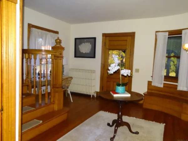a view of a livingroom with wooden floor and furniture