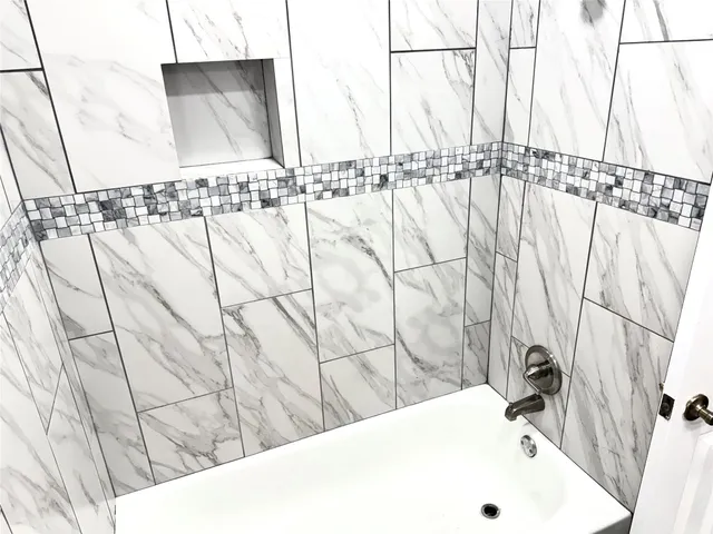 a bathroom with a bathtub and shower