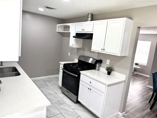 a kitchen with stainless steel appliances a white stove top oven and a white refrigerator