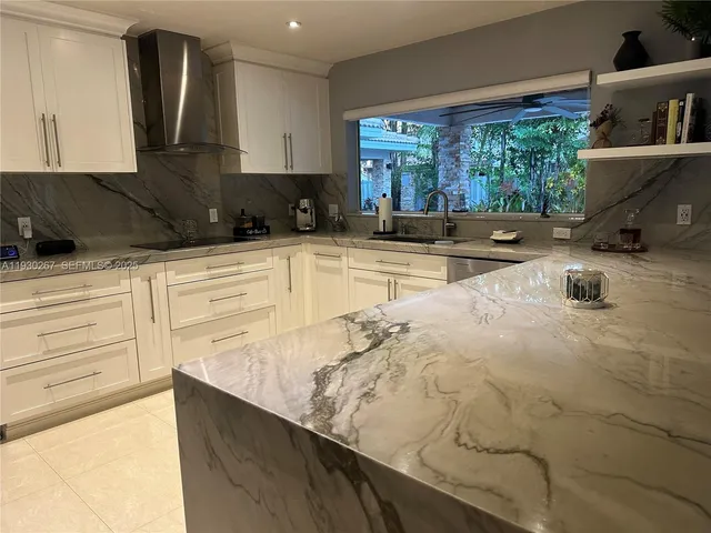 a kitchen with stainless steel appliances granite countertop a sink and a refrigerator