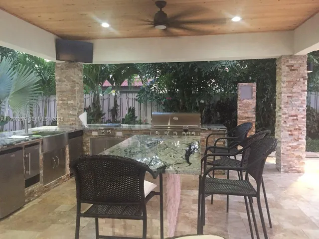 a living room with patio furniture and a potted plant