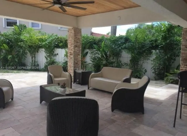 a view of a patio with a table and chairs and a barbeque