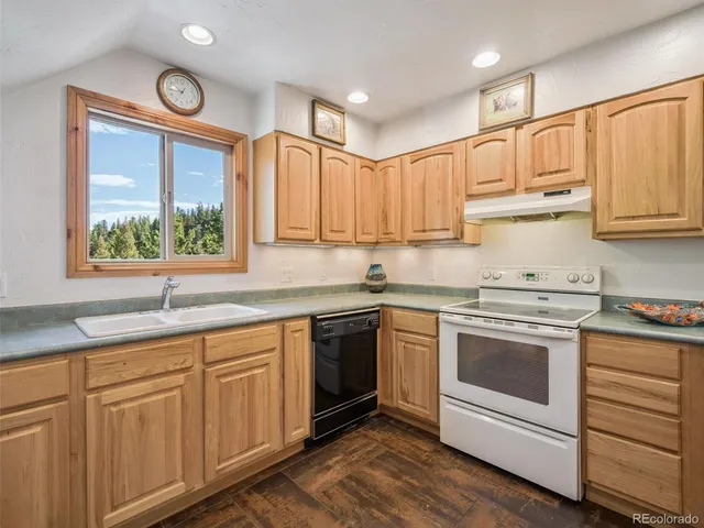 a kitchen with granite countertop white cabinets and white stainless steel appliances