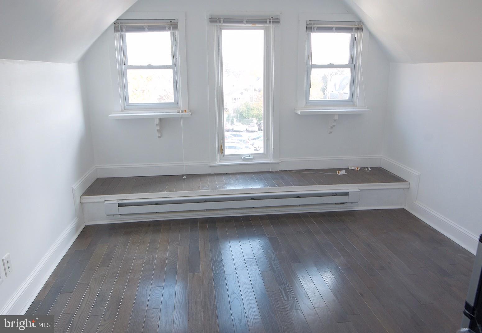 an empty room with wooden floor and a window