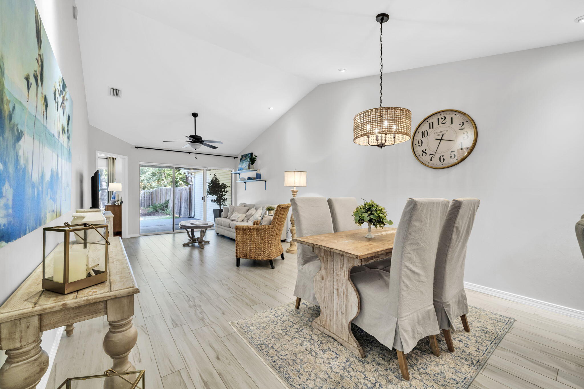 a dining room with wooden floor a chandelier a wooden table and chairs