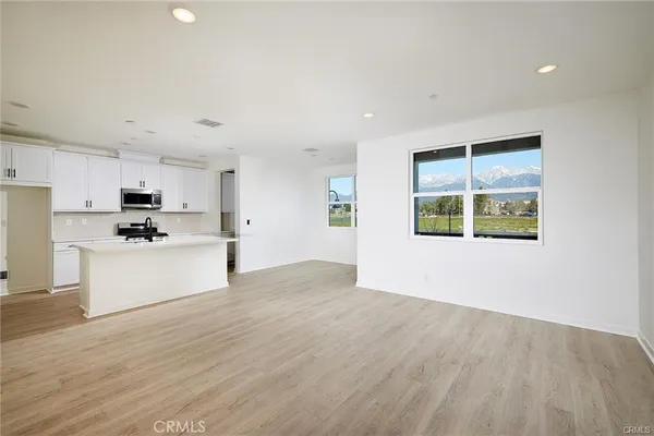 a view of a kitchen with wooden floor and windows